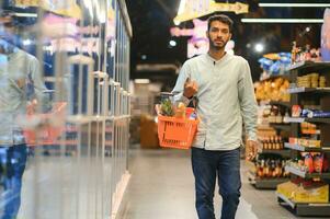 retrato de indio masculino en tienda de comestibles con positivo actitud foto