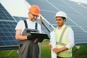 The solar farm solar panel with two engineers walk to check the operation of the system photo