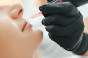 Banner Process woman applying permanent tattoo makeup on lips in beautician salon photo