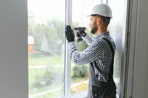 Construction worker installing window in house. photo