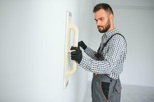 joven trabajador haciendo reparar en habitación. foto