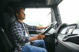 Portrait of a young handsome Indian truck driver. The concept of logistics and freight transportation. photo