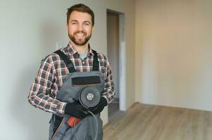 Portrait of a confident repairman with beard standing in empty apartment photo