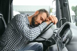 Man trucker tired driving in a cabin of his truck photo