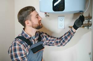 Professional engineer installing a natural gas boiler at home, he is checking the pipes photo