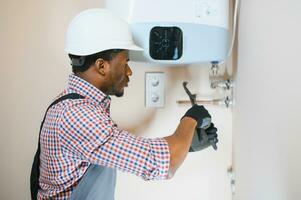 African american worker set up central gas heating boiler at home photo