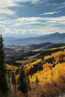 AI generated A scenic view capturing golden autumn foliage, rolling terrains, distant majestic mountains and a beautifully patterned sky. photo