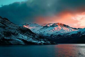 AI generated a snowy mountain range beside a serene lake under a vibrant, colorful evening sky. The mountains are intricately detailed and feature a variety of contours photo