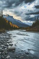 AI generated A rocky riverbed with clear flowing water is in the foreground. The banks of the river are adorned with trees showcasing autumn foliage. photo