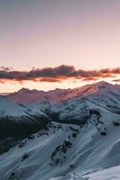 AI generated Majestic mountains bathed in sunrise light, showcasing a blend of snow-covered peaks and rocky surfaces. photo