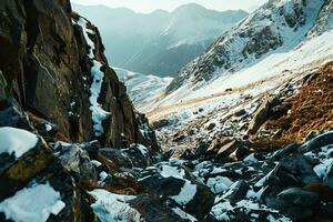 AI generated A breathtaking view of snow-capped mountains, rugged rocks adorned with snow, and sunlit golden grasses offering a serene and majestic landscape. photo