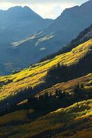 AI generated A breathtaking view of golden autumn foliage against the backdrop of majestic, rugged mountains under a clear sky. photo