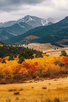 AI generated Vibrant autumn colors in forest, snow-capped peaks background, overcast atmosphere, serene nature view. photo