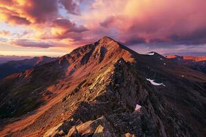 AI generated A breathtaking sunset illuminating a rugged mountain landscape, casting golden hues on rocky peaks amidst a dramatic sky. photo