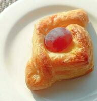 pastry with grape decoration on plate photo