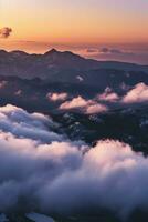 AI generated A breathtaking view of mountains amidst clouds at sunset, showcasing nature's grandeur and tranquility. photo