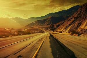 ai generado un asombroso ver de un tranquilo la carretera extensión mediante un majestuoso montaña rango debajo el dorado matices de un ajuste Dom. foto