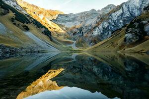 ai generado un asombroso ver de un montañoso paisaje reflejado perfectamente en un tranquilo lago, iluminado por el dorado rayos de el ajuste Dom. foto