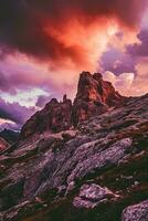AI generated A breathtaking view of rugged mountains under a vibrant sunset. The rocky terrain is highlighted by the dramatic contrast of the darkening skies. photo
