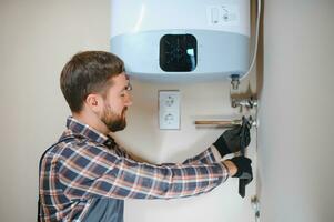 Professional engineer installing a natural gas boiler at home, he is checking the pipes photo