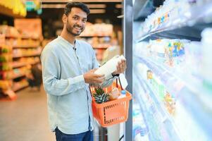 retrato de contento hermoso joven indio a tienda de comestibles tienda o supermercado. foto