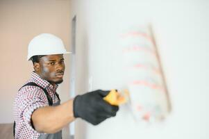 African-American painter doing repair in room photo