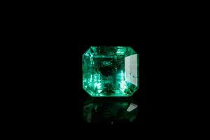 Macro mineral Emerald gemstone faceted on black background photo