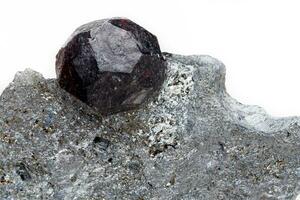 Macro mineral stone garnet  in the rock on a white background photo