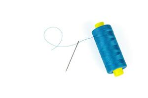 Macro skein of blue thread with a needle on a white background photo