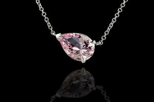 beautiful Morganite pendant in gold with a chain on a black background photo