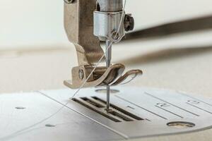 Sewing machine needle with thread and fabric photo