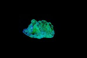 macro mineral stone opal under ultraviolet light on a black background photo