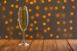 Glasses with champagne on a wooden background against a bokeh background of lights photo