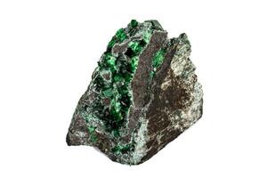 Macro stone garnet mineral, Uvarovite in rock on a white background photo