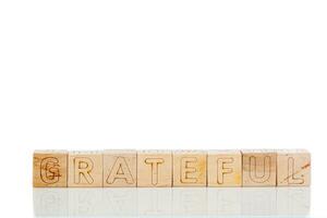 Wooden cubes with letters gratrful on a white background photo