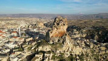 antenn Drönare se av de ortahisar slott i Kappadokien, Kalkon med de snö capped montera erciyes i de bakgrund. människor njuter de se från de topp av de slott. video