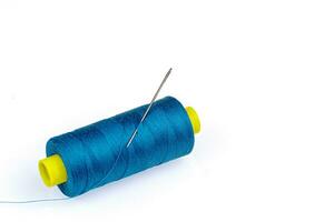 Macro skein of blue thread with a needle on a white background photo