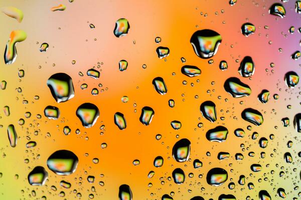 Beautiful multi-colored water droplets on a glass