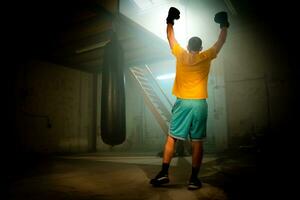 Boxer celebrating win on dark background. Horizontal copy space sport background. photo