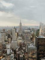 Aerial view of a city skyline with iconic skyscrapers under a cloudy sky, showcasing urban architecture. photo