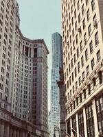 Vintage-toned cityscape with old and modern skyscrapers under a clear sky. photo