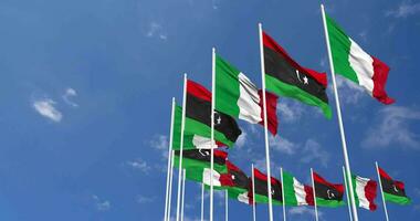 Libia e Italia bandiere agitando insieme nel il cielo, senza soluzione di continuità ciclo continuo nel vento, spazio su sinistra lato per design o informazione, 3d interpretazione video