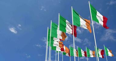 Irlanda e Italia bandiere agitando insieme nel il cielo, senza soluzione di continuità ciclo continuo nel vento, spazio su sinistra lato per design o informazione, 3d interpretazione video