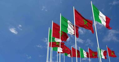 Maroc et Italie drapeaux agitant ensemble dans le ciel, sans couture boucle dans vent, espace sur la gauche côté pour conception ou information, 3d le rendu video