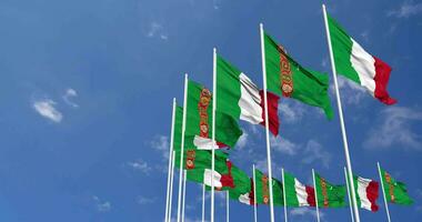 Turkmenistan and Italy Flags Waving Together in the Sky, Seamless Loop in Wind, Space on Left Side for Design or Information, 3D Rendering video