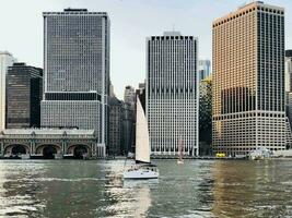 velero en río con ciudad horizonte fondo a oscuridad. foto