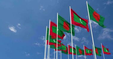 Maldive e bangladesh bandiere agitando insieme nel il cielo, senza soluzione di continuità ciclo continuo nel vento, spazio su sinistra lato per design o informazione, 3d interpretazione video