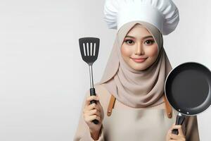 ai generado un asiático hembra cocinero en un hijab participación un espátula en un blanco antecedentes foto