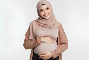 AI generated Asian woman in hijab with pose holding pregnant belly and smiling facial expression isolated white background photo