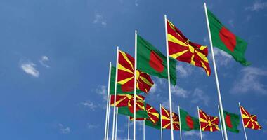 nord macedonia e bangladesh bandiere agitando insieme nel il cielo, senza soluzione di continuità ciclo continuo nel vento, spazio su sinistra lato per design o informazione, 3d interpretazione video